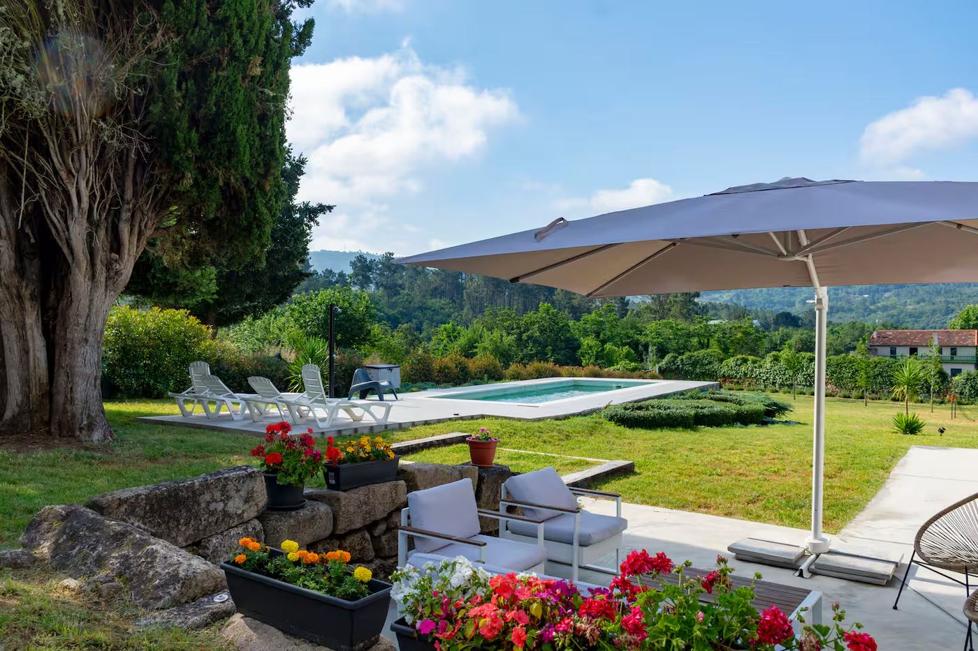 Jardín con piscina y sombrilla