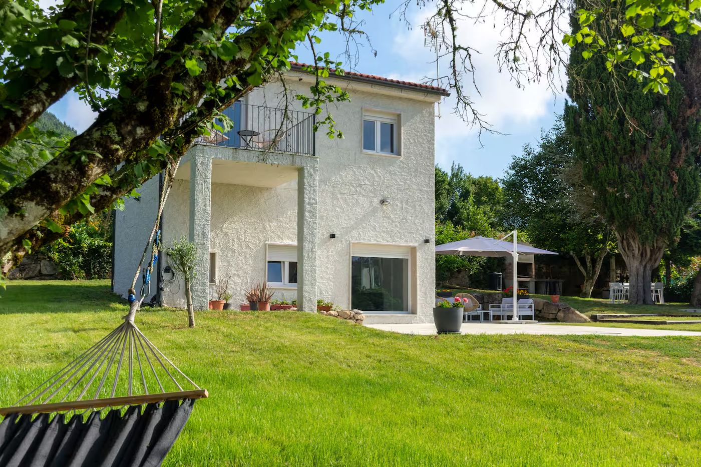 Exterior casa con jardín y ciprés
